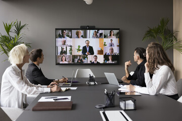 Fototapeta premium Group meeting using video call app. Multiethnic businesspeople profiles on screen, engaged in teleconference event by business, international communication of HR managers and applicants, career, tech