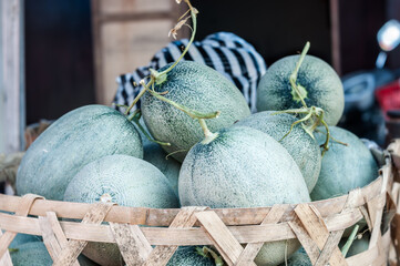 A basket filled with ripe muskmelons, captured at a bustling market in Bali.