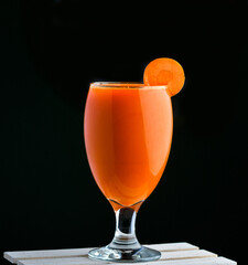 glass of fresh Carrot juice with a slice of carrot on glass