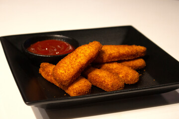 Chicken fillet fingers with tomato ketchup in a plate