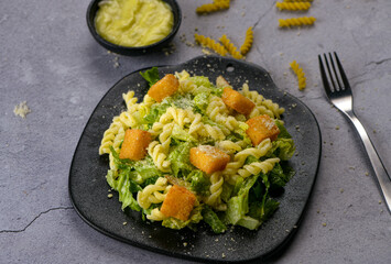 Rigid tangled fusilli Caesar pasta , multi grained panini toasted bread, grilled chicken, freshly shaved Parmesan cheese and dressing