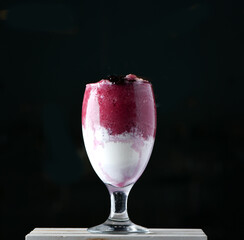 A well mixture of blackberry with vanilla ice cream in crushed ice