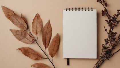Notepad copyspace on tan begie background with dry brown branches. Autumn minimal flatlay blank pages template muckup