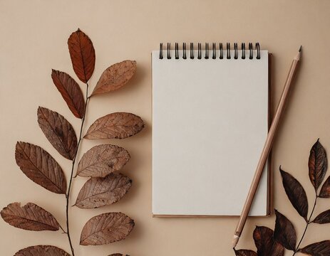 Notepad copyspace on tan begie background with dry brown branches. Autumn minimal flatlay blank pages template muckup