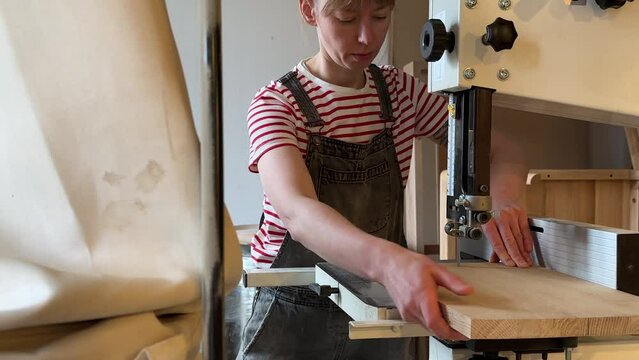 Carpenter woman working on jig saw. Focused female joiner carved on wood with help of sabre saw machine. Carpentry workshop. Concentrated work requires attentiveness accuracy manual dexterity.