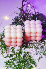 Cute white and pink Bubble candles on purple background. 