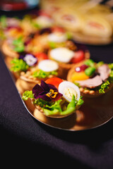 tartlets with pate and salad garnished with flowers. Delicious appetizers.