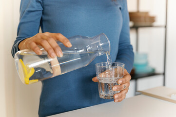 woman pouring glass from bottle into glas