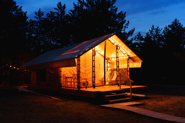 Glamping from tent houses in the forest in the dark. 