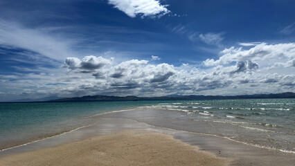 sandbank in Fiji under a blue cloudy sky