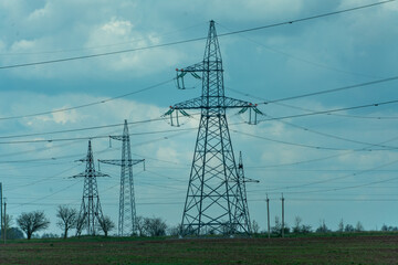 High voltage towers with sky background. Power line support with wires for electricity transmission. High voltage grid tower with wire cable at distribution station. Energy industry, energy saving