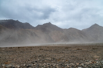 Sand storm with Himalayan mountain and dramatic clouds in the background at Sand Dunes in Hunder,Nubra Valley, Diskit, Ladakh