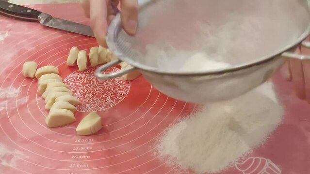 Preparation of dumplings. Stage 7. Dip the pieces of dough in flour