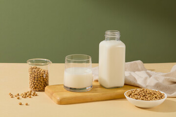 Soy Milk is contained in a bottle and a glass on rectangle wooden tray. Soy milk is a nutritious beverage that’s low in calories, high in protein, and rich in several vitamins and minerals