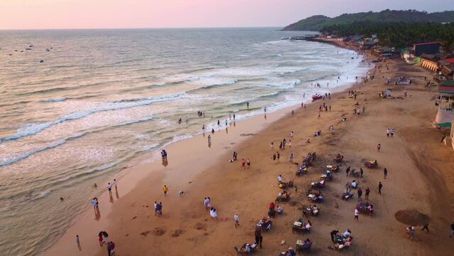 Drone shot of people enjoying and relaxing at goa beach at evening  at Sunset.