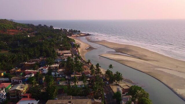 beautiful Drone shot of Goa beach coastline with coconut and palm trees during sunset