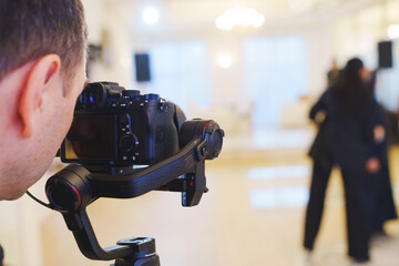 A professional camera on the blurred background of a banquet hall. 