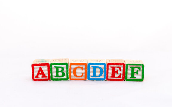 Closeup wooden letter toy arranged the word ABCDEF in a row isolated on white background
