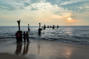 Old ruined sea piers in Calicut Kozhikode beach in Kerala India. Silhouettes of sea piers during the sunset