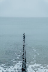 Old wooden breakwater on the background of the Baltic Sea