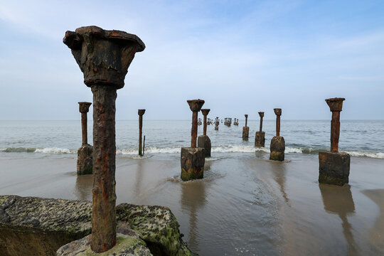 Old ruined sea piers in Calicut Kozhikode beach in Kerala India. Silhouettes of sea piers during the sunset