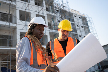 Worker engineer African woman working with caucasian worker at construction site	