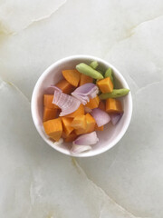 Ingredients ( carrots ,garlics, red onions, red chilli, green chilli, tumeric and salt ) on the table background