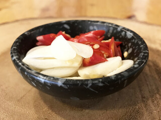 Sliced red chilies and garlic are placed in a bowl, to be used as a side dish or added to chili paste or cooked food background.Chili garlic, besides cooking, has hundreds of benefits.