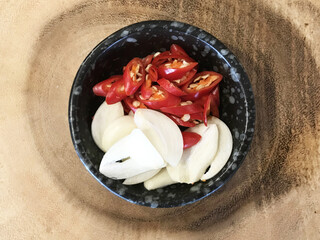 Sliced red chilies and garlic are placed in a bowl, to be used as a side dish or added to chili...