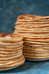 Flatbread lavash, chapati, naan, heap of tortilla on a blue background Homemade flatbread stacked.