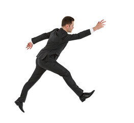 A businessman in a suit running posed against a white background, depicting urgency or haste
