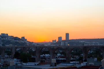 Fototapeta na wymiar beautiful sunrise in the city center seen from a viewpoint overlooking a beautiful arched aqueduct