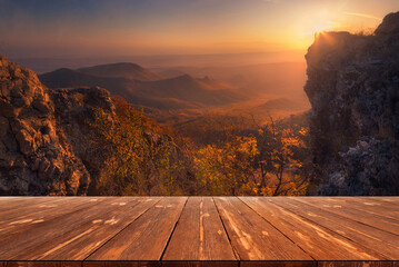 Summer beautiful background with sunset over mountains and empty wooden table in nature outdoor....
