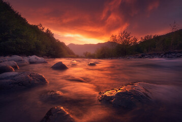 Fototapeta na wymiar fast mountain river flowing In sunset time