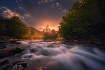 beautiful sunrise over fast flowing mountain river