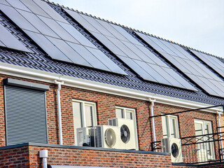 air source heat pump unit installed outdoors at a modern home with solar panels in the Netherlands, Zonnepanelen, Zonne energie, Translation: Solar panel, Sun Energy