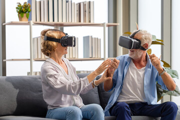 Senior mature couple sitting on the sofa having fun with virtual reality glasses, Happy elderly technology concepts