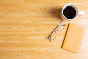 机の上のコーヒーとノートと眼鏡