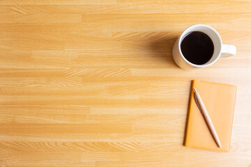 机の上のノートとコーヒー