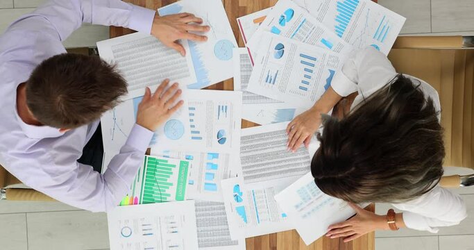 wo business professionals analyze and discuss complex financial data and graphs