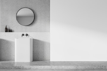 Minimalist bathroom interior with a round mirror, a white sink, and decorative bottles against a...