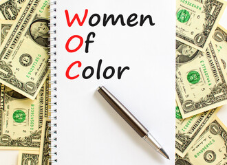 WOC women of color symbol. Concept words WOC women of color on beautiful white note. Dollar bills....