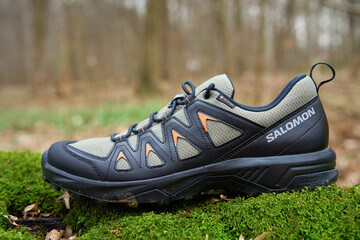 Salomon X Braze GTX hiking boots with Gore-Tex membrane on vibrant green moss. Trekking shoes in nature. Concept of exploration and outdoor activities
