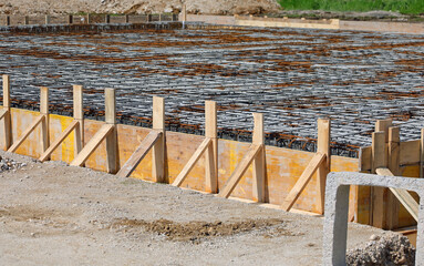 building formwork made with yellow wooden planks during laying cement to make the foundation of the building - 783596188