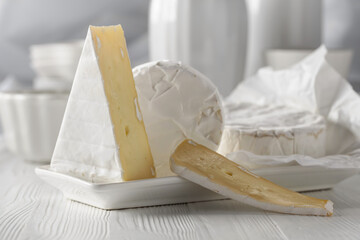 Camembert cheese on a white wooden table.