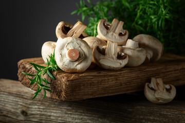 White champignons with rosemary on a wooden board. - 783597137