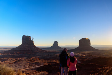 The tourists are admiring the view of West Mitten Butte in Monument Valley, USA, traveling during...