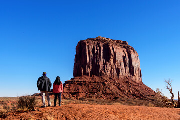 The tourists are admiring the iconic rock formations in Monument Valley, USA, while traveling...