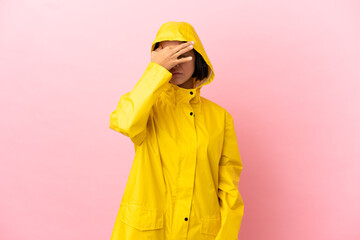Young latin woman wearing a rainproof coat over isolated background with headache