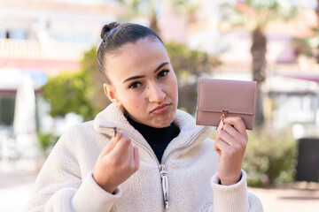 Young moroccan girl  at outdoors holding a wallet and with sad expression